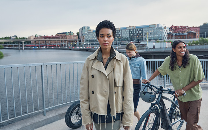 Tre personer med elcyklar på en bro