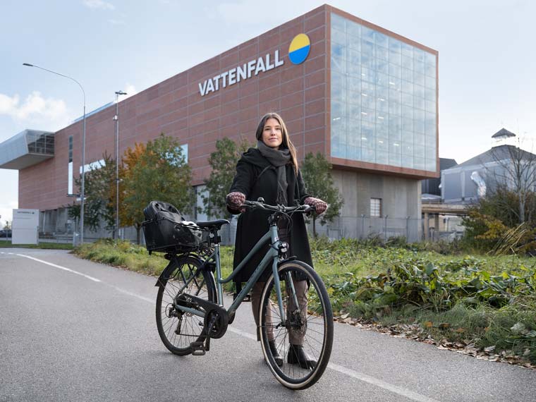 Kvinna med cykel utanför vår avfallsanläggning i Uppsala