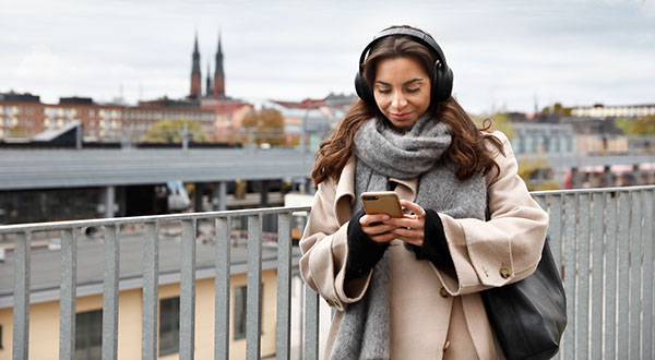 Kvinna utomhus som håller i en mobiltelefon