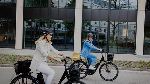 Två kvinnor på elcyklar